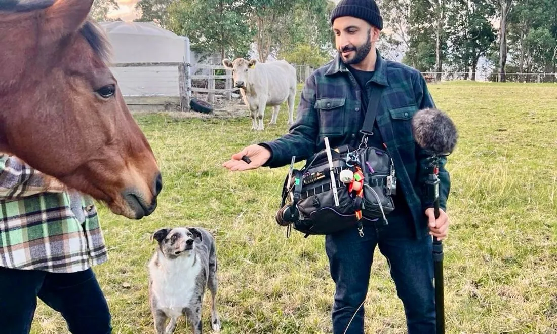 Mike Jaballah recording location sound in a paddock with a horse at sunset