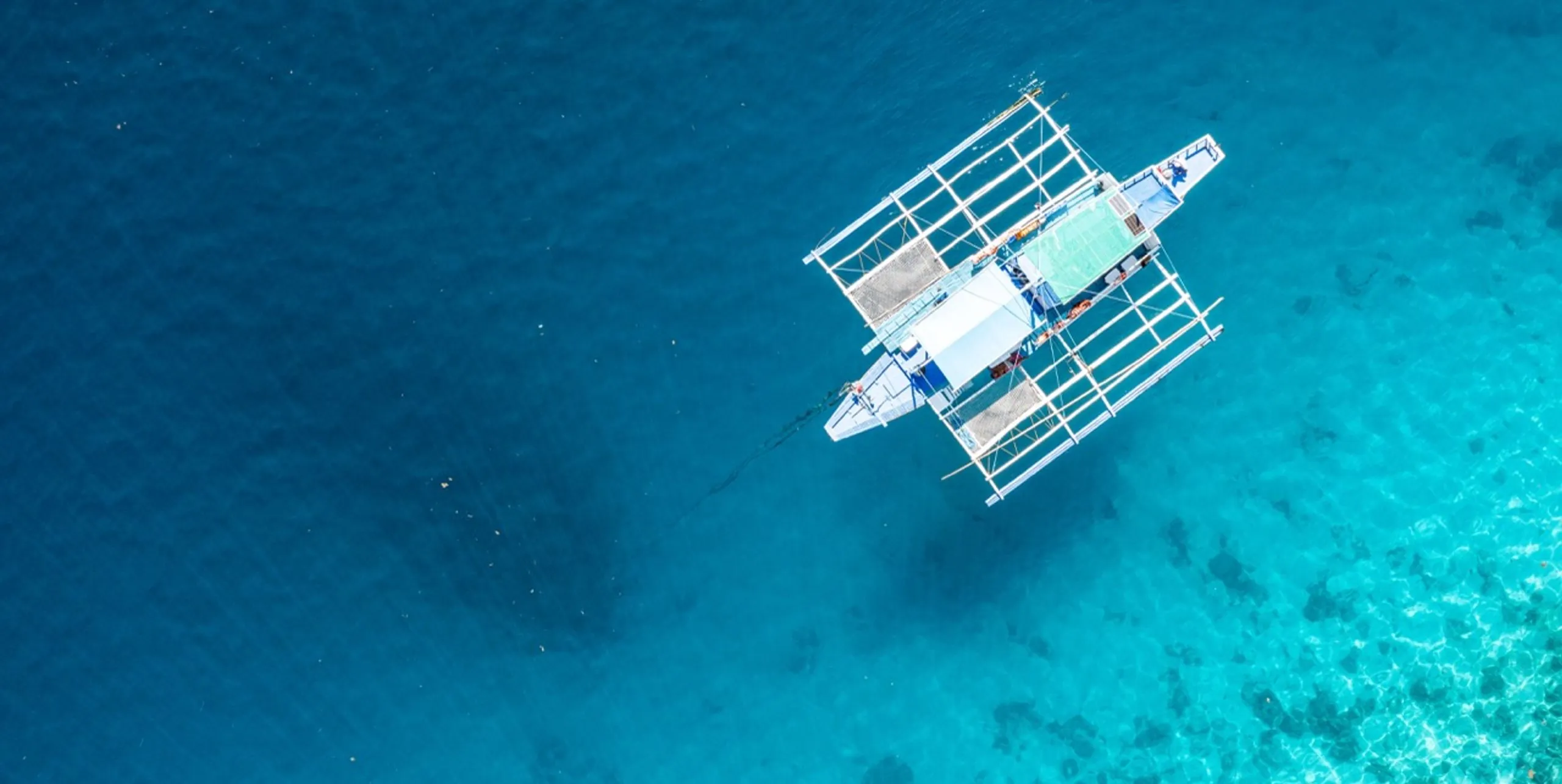 Drone view of an outrigger boat on the water at Coron