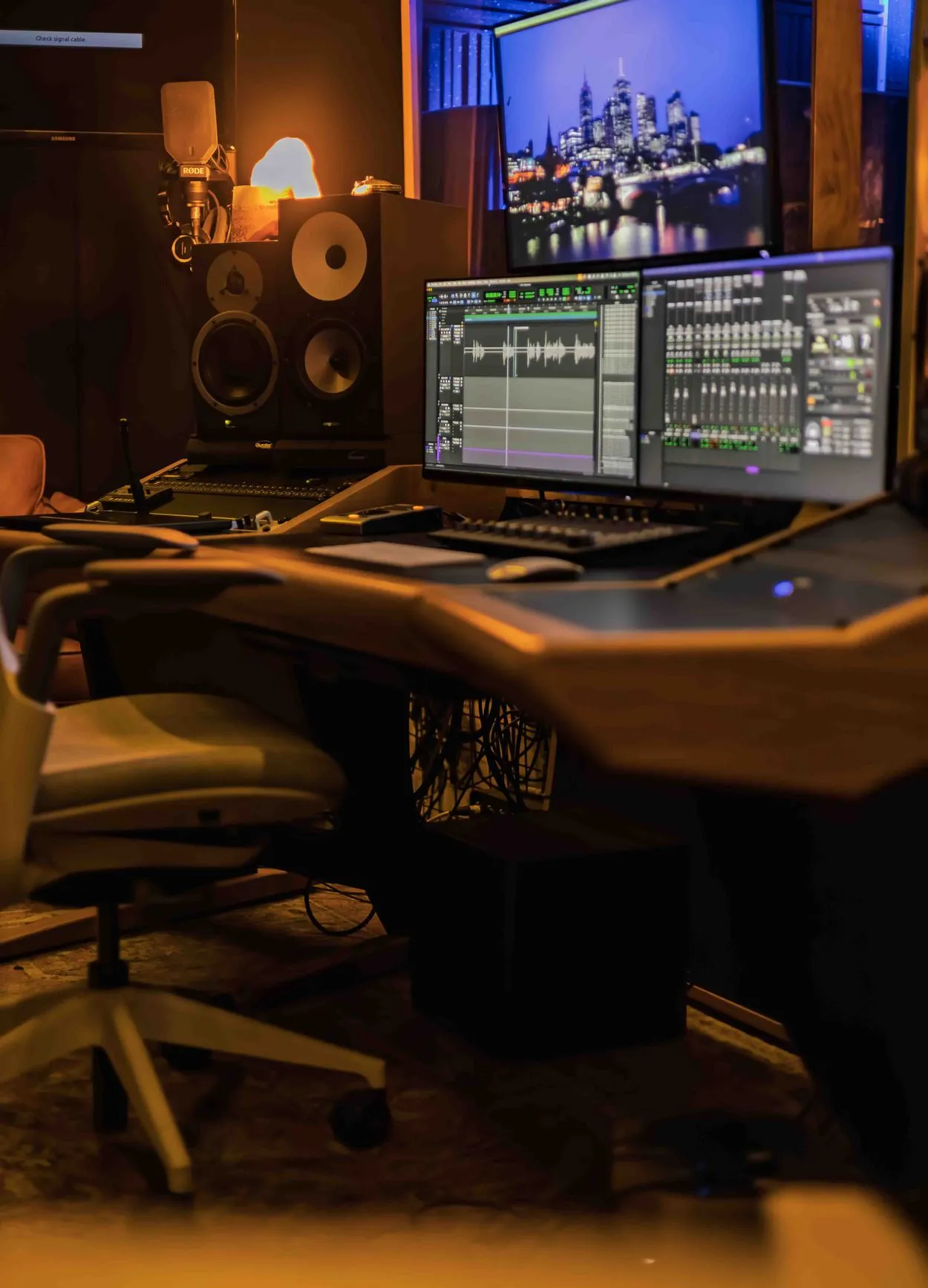 Audio post production studio with a Pro Tools session on screen, studio monitors and a RODE mic