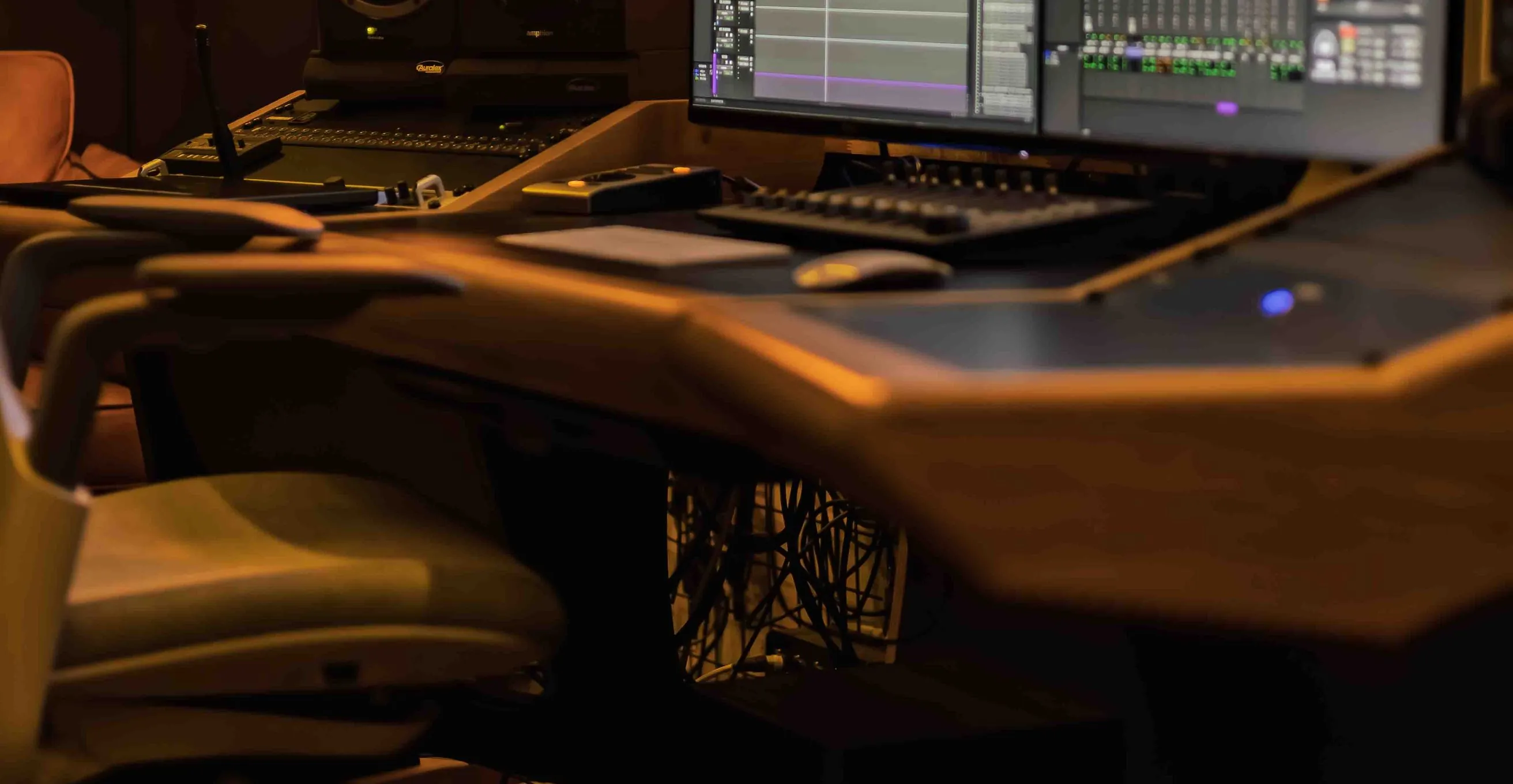 Audio post production studio with a Pro Tools session on screen, studio monitors and a RODE mic