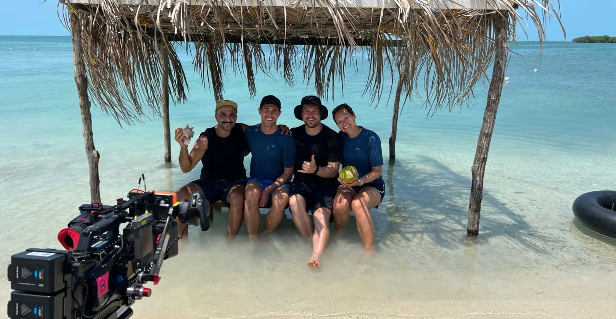 Mike Jaballah with Heath and Tony from The Amazing Race, sitting in the water in Belize after an interview